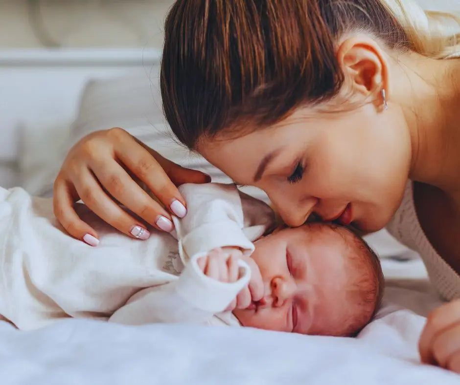 nya szeretettel nézi kisbabáját, miközben alszik