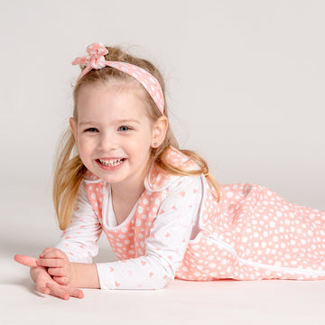 Kislány LiaaBébé Masnit visel, világos rózsaszín színben, pöttyökkel.