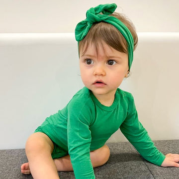 Kislány Zöld Bodyban ül